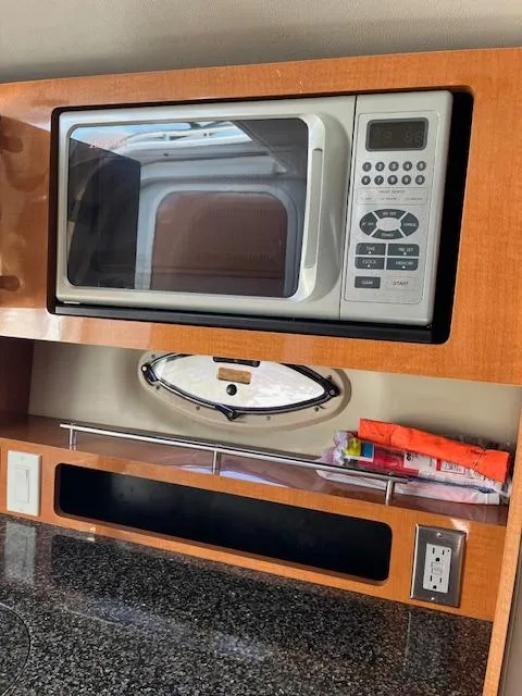 Slide: The Image of 2008 Chaparral Signature 250 interior with microwave, wooden cabinetry, and granite countertop. - 15