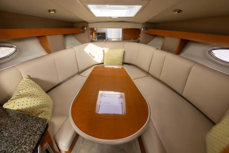 Slide: The Image of 2008 Chaparral Signature 250 cabin interior with beige seating and wooden table. - 20