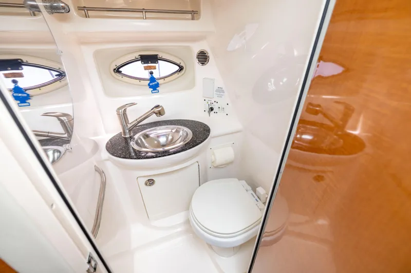 Slide: The Image of 2008 Chaparral Signature 250 boat bathroom with sink, toilet, and porthole window. - 21
