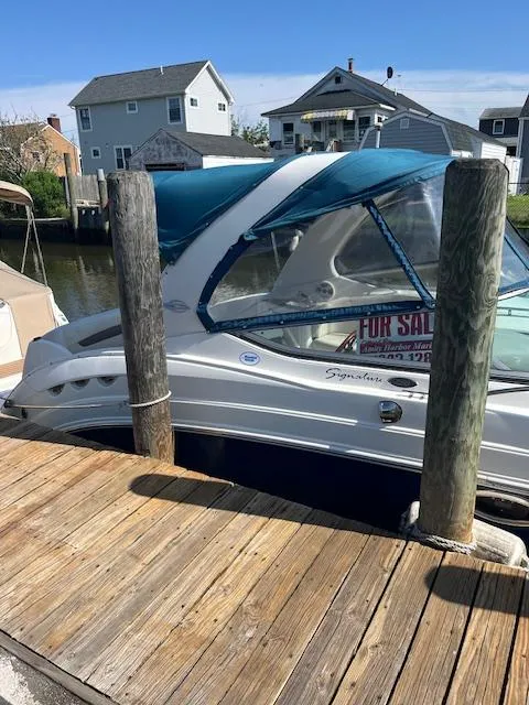 Slide: The Image of 2008 Chaparral Signature 250 boat docked, for sale sign visible, residential background. - 3