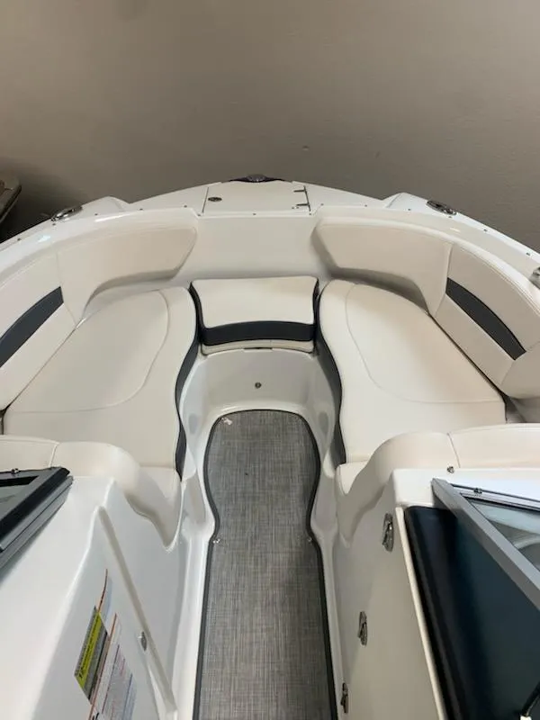 Slide: The Image of 2018 Chaparral 224 Sunesta boat interior with white seating and gray flooring. - 2