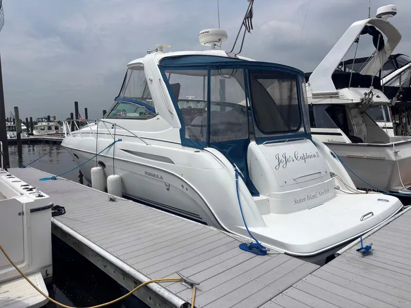 The Image of 2005 Formula 37 PC yacht docked at marina, featuring sleek design and blue canopy. - 0