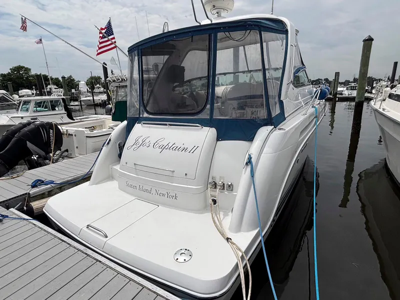 Slide: The Image of 2005 Formula 37 PC yacht docked, featuring blue canopy and American flags, Staten Island, New York. - 2