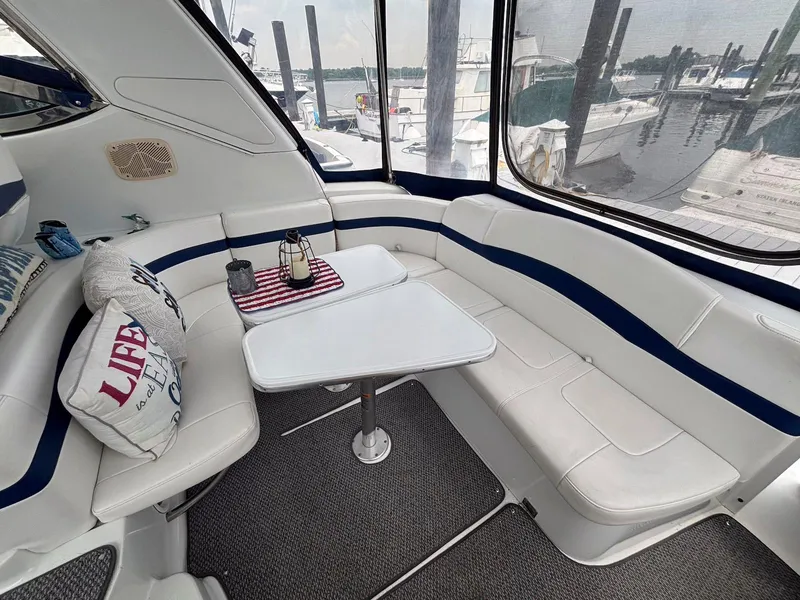 Slide: The Image of 2005 Formula 37 PC yacht interior with white seating, table, and marina view. - 5