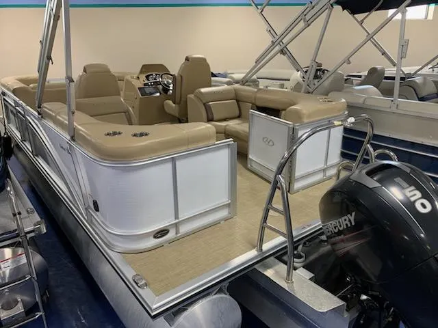Slide: The Image of 2018 Harris Cruiser 220 pontoon boat with beige seating and Mercury outboard motor. - 4