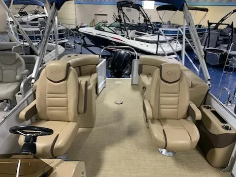 Slide: The Image of 2018 Harris Cruiser 220 pontoon boat with beige seating in a showroom. - 6
