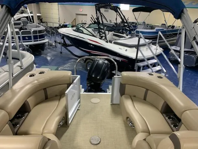 Slide: The Image of 2018 Harris Cruiser 220 pontoon boat interior with tan seating, displayed in a showroom. - 7