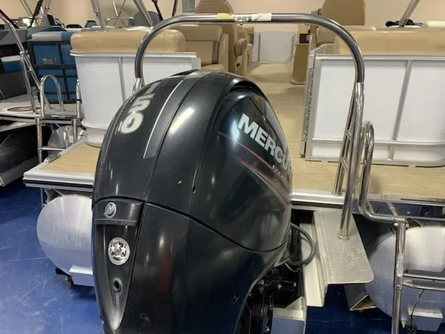 Slide: The Image of 2018 Harris Cruiser 220 pontoon boat with Mercury outboard motor, beige seating, and blue flooring. - 9