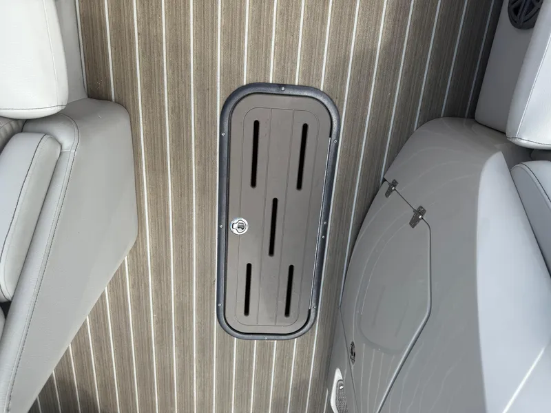 Slide: The Image of 2017 Manitou 24 Legacy Triple Tube boat interior with striped flooring and seating. - 10