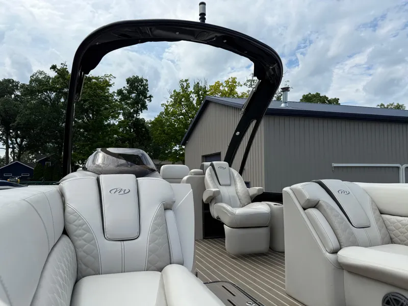 Slide: The Image of 2017 Manitou 24 Legacy Triple Tube boat with luxurious white seating and sleek design. - 14