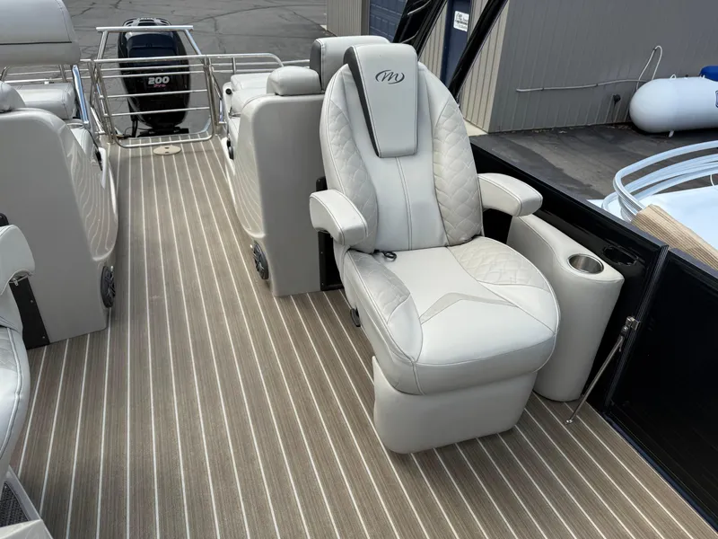 Slide: The Image of Luxurious seating on 2017 Manitou 24 Legacy Triple Tube pontoon boat with striped flooring. - 17