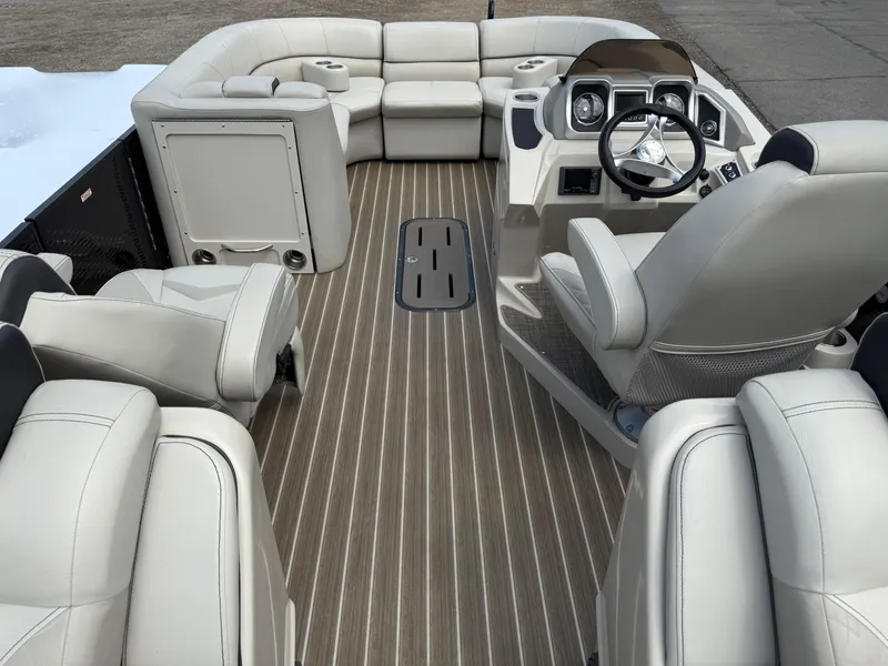 Slide: The Image of 2017 Manitou 24 Legacy Triple Tube boat interior with luxurious seating and modern dashboard. - 28