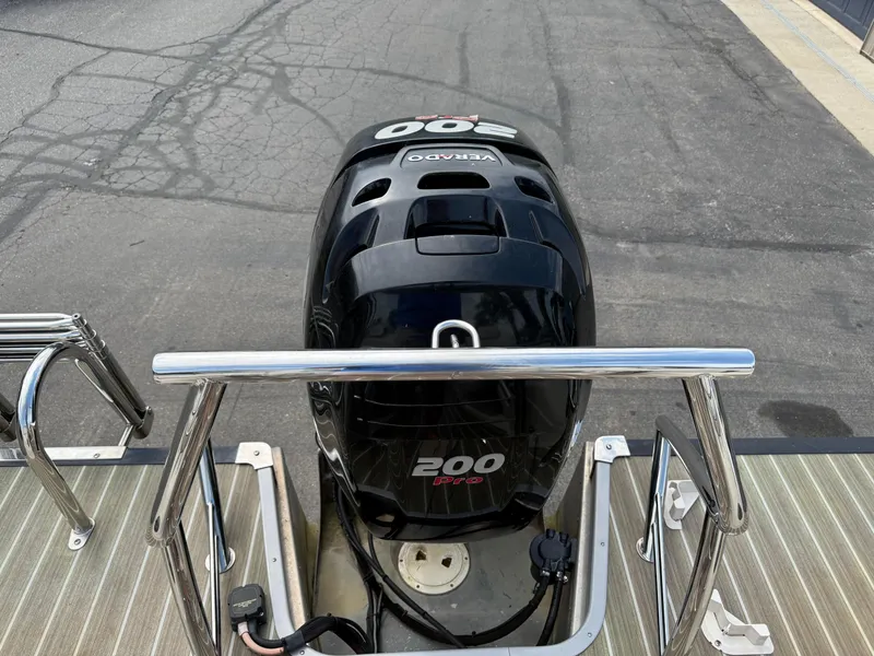 Slide: The Image of 2017 Manitou 24 Legacy Triple Tube with 200 Pro outboard motor on a dock. - 30