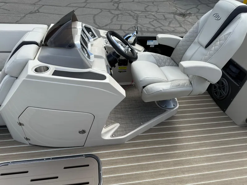 Slide: The Image of Captain's seat and console of 2017 Manitou 24 Legacy Triple Tube boat. - 9