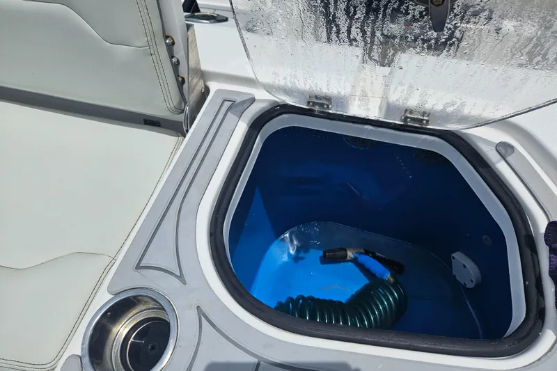 Slide: The Image of Open storage compartment on 2022 Sea Cat 260 Hybrid boat with coiled hose inside. - 34