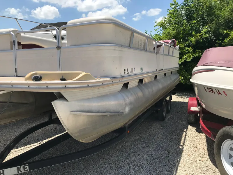 The Image of 2000 Fisher Freedom 241 DLX pontoon boat on trailer, parked outdoors. - 1