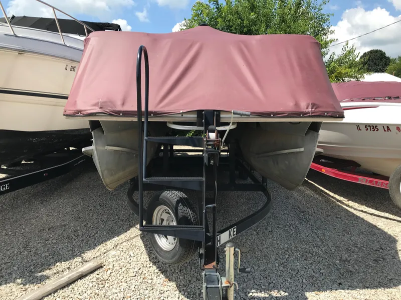 Slide: The Image of 2000 Fisher Freedom 241 DLX boat with maroon cover on trailer, parked on gravel. - 17