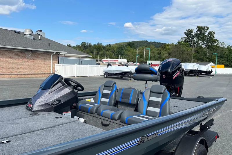 Slide: The Image of 2026 Ranger RT188 boat with dual seats and motor, parked outdoors under a clear sky. - 10