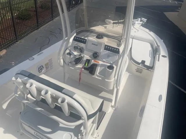 Slide: The Image of 2023 Robalo 206 Cayman boat on trailer, displayed outside dealership. - 2