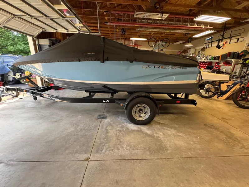 Slide: The Image of 2021 Regal 1900 ES boat with cover on trailer in garage. - 2