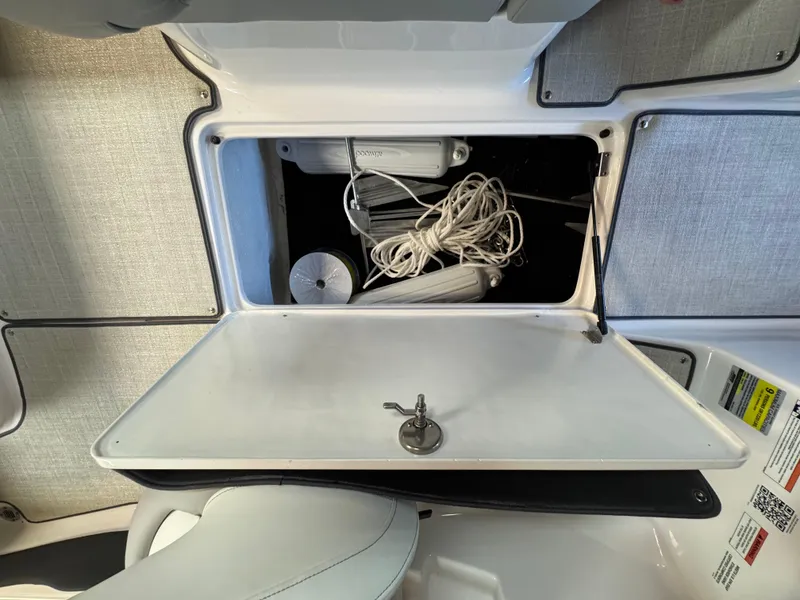 Slide: The Image of Open storage compartment in 2021 Regal 1900 ES boat, containing ropes and accessories. - 7