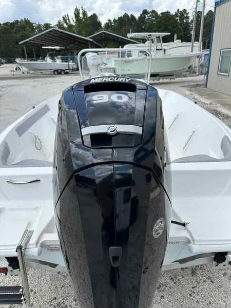 Slide: The Image of Kenner 18 CRS 2022 boat with Mercury 90 outboard motor, parked outdoors. - 11