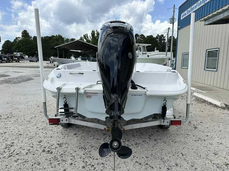 Slide: The Image of 2022 Kenner 18 CRS boat with outboard motor on trailer, parked outdoors. - 2