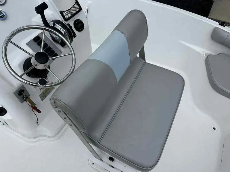 Slide: The Image of 2022 Kenner 18 CRS boat interior with steering wheel and cushioned seat. - 6