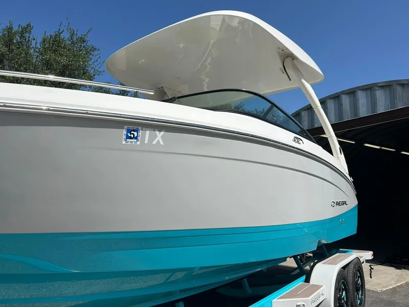 Slide: The Image of 2022 Regal LS4 Surf boat with sleek design and vibrant blue hull. - 11
