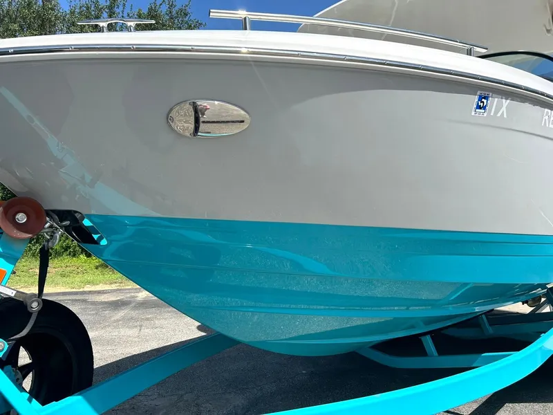 Slide: The Image of 2022 Regal LS4 Surf boat with sleek turquoise hull on trailer. - 12