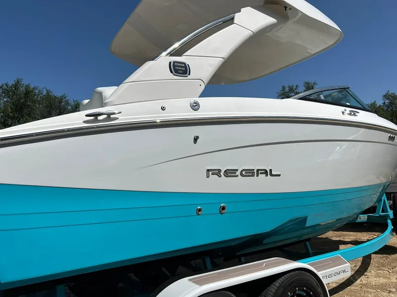 Slide: The Image of 2022 Regal LS4 Surf boat with sleek design and vibrant blue hull. - 20