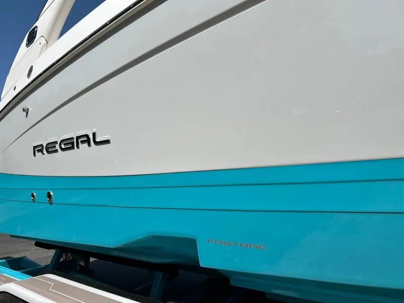 Slide: The Image of 2022 Regal LS4 Surf boat with blue and white hull, featuring FasTrac design. - 21