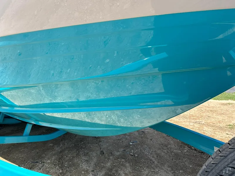 Slide: The Image of 2022 Regal LS4 Surf boat hull in vibrant turquoise on trailer. - 22