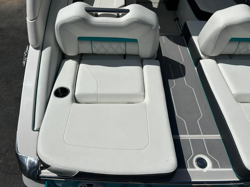 Slide: The Image of 2022 Regal LS4 Surf boat interior with white cushioned seating and cup holder. - 32