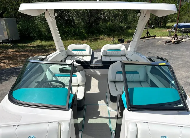 Slide: The Image of 2022 Regal LS4 Surf boat with white and teal interior, featuring open seating and a sleek design. - 4