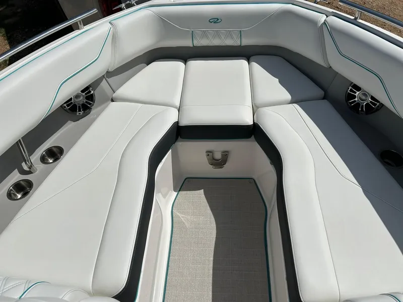 Slide: The Image of 2022 Regal LS4 Surf boat interior with white cushioned seating and cup holders. - 6