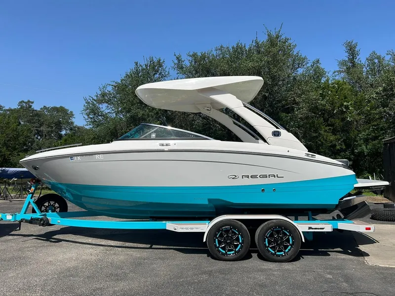 Slide: The Image of 2022 Regal LS4 Surf boat on trailer, featuring sleek design and vibrant blue hull. - 7
