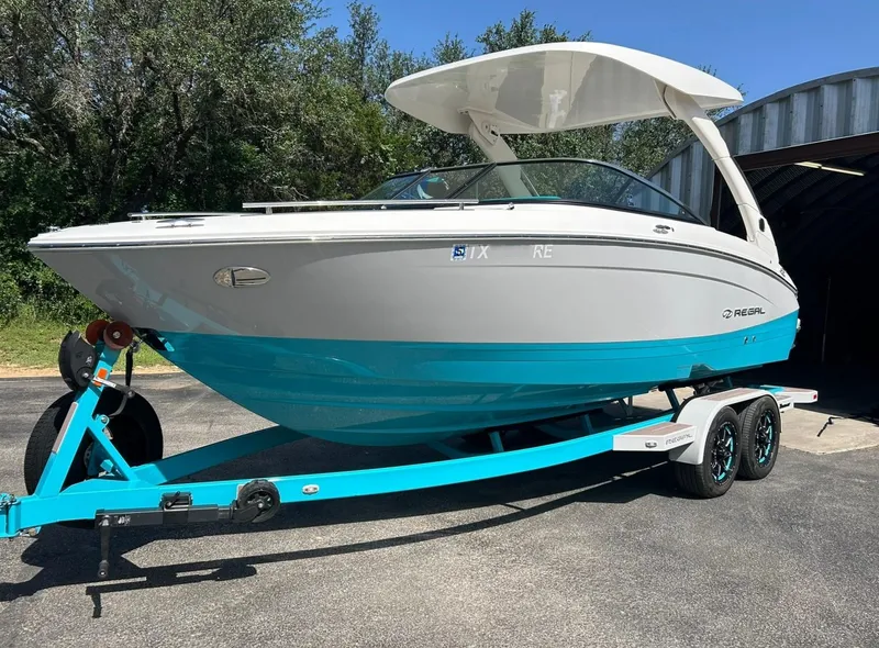 Slide: The Image of 2022 Regal LS4 Surf boat on a trailer, parked outdoors. - 9