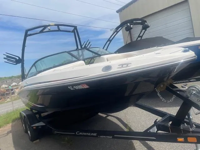 Slide: The Image of 2013 Sea Ray 205 Sport boat on trailer, parked outdoors near a building. - 2
