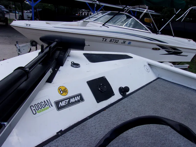 Slide: The Image of 2008 G3 1860 CC Deluxe boat with fishing gear and stickers, parked near another boat. - 9