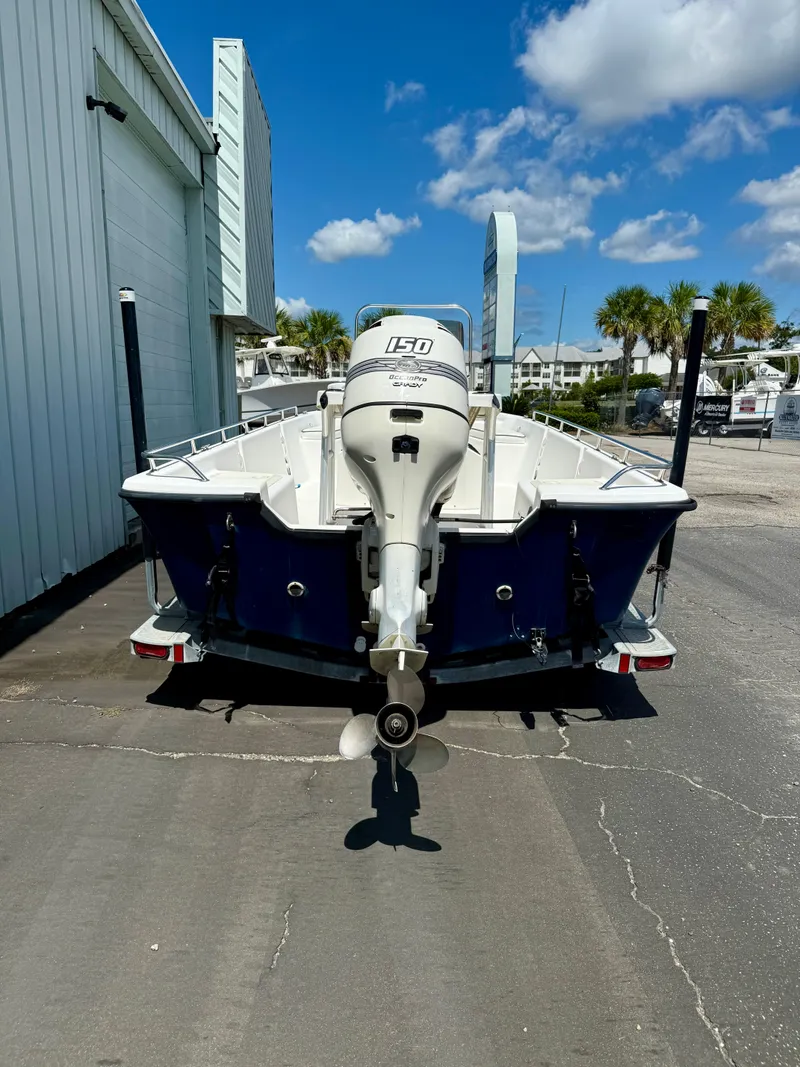 Slide: The Image of Kenner Vision 2102 boat, 2001 model, with outboard motor, parked outdoors on a sunny day. - 2