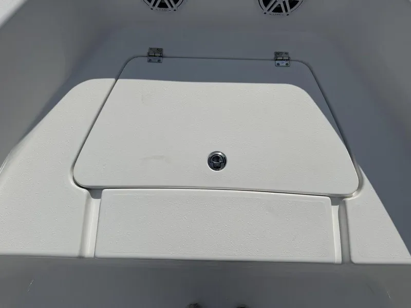 Slide: The Image of 2026 Tidewater 180 CC Adventure boat storage compartment with secure latch and speakers. - 14