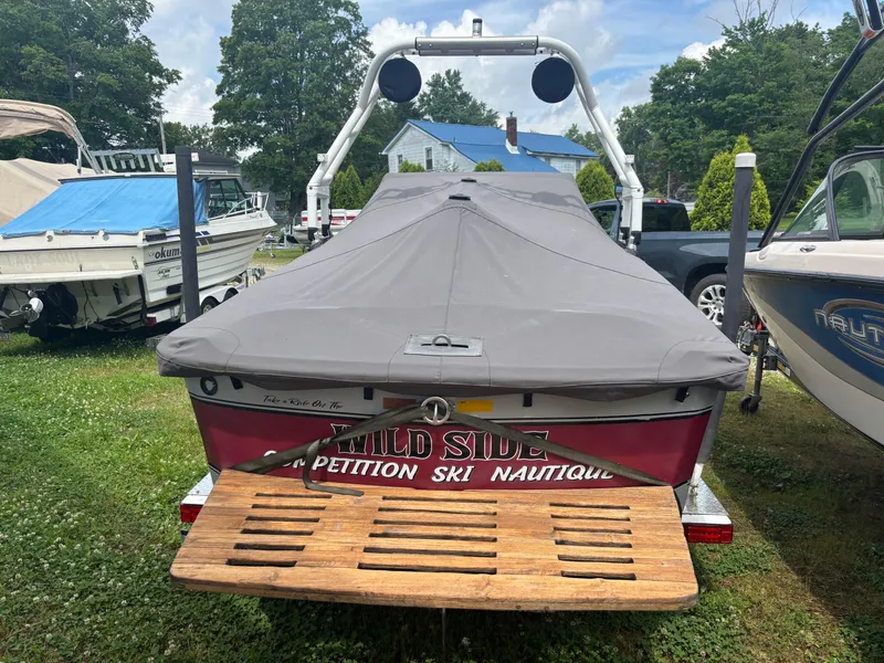 Slide: The Image of 1989 Correct Craft Ski Nautique boat with cover, parked on trailer in grassy area. - 10