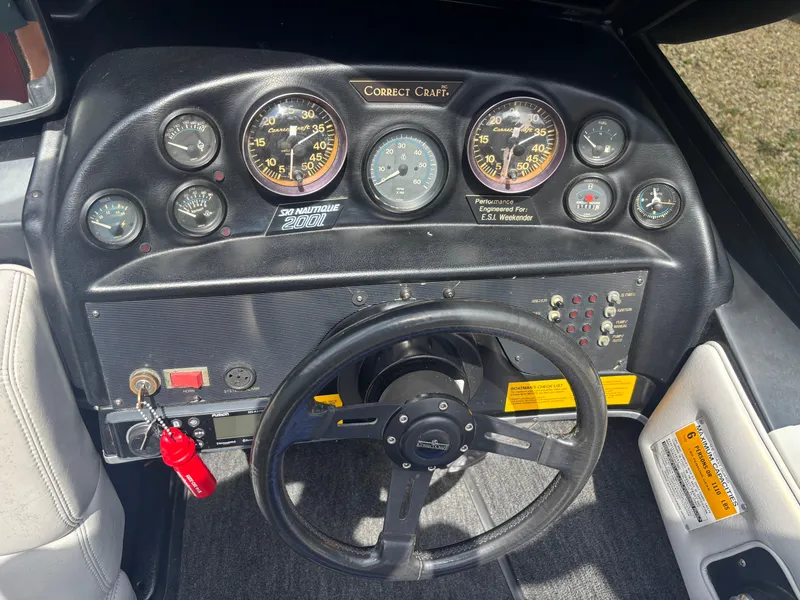 Slide: The Image of 1989 Correct Craft Ski Nautique dashboard with gauges and steering wheel. - 11