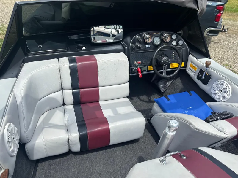 Slide: The Image of 1989 Correct Craft Ski Nautique interior with maroon and black seating, dashboard, and steering wheel. - 13