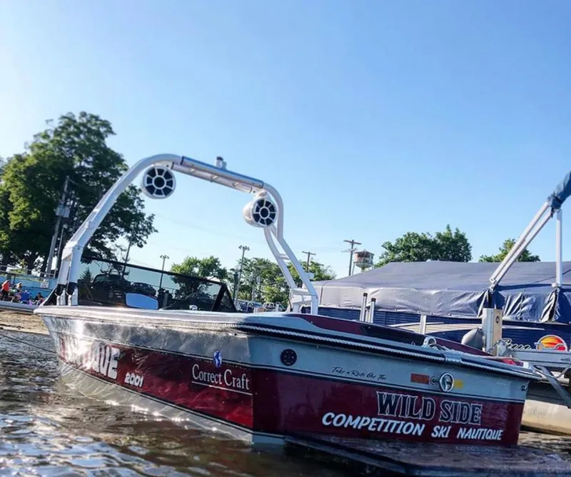 Slide: The Image of 1989 Correct Craft Ski Nautique boat docked by the shore, featuring "Wild Side" graphics. - 8