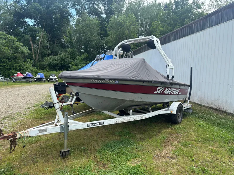 Slide: The Image of 1989 Correct Craft Ski Nautique boat on trailer, covered, parked outdoors. - 9