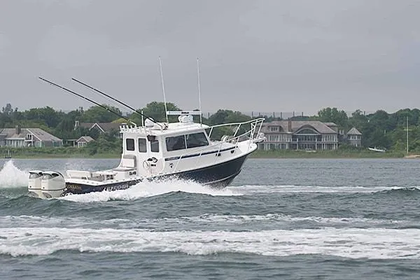 Slide: The Image of 2026 Steiger Craft 31 Miami boat cruising on a lake with houses in the background. - 11