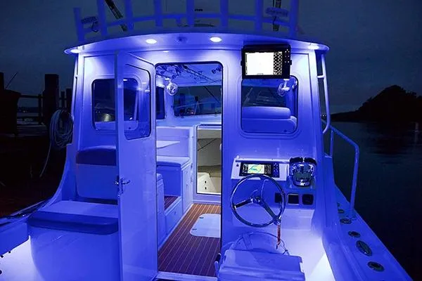Slide: The Image of 2026 Steiger Craft 31 Miami boat interior with blue LED lighting at night. - 14