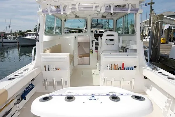 Slide: The Image of 2026 Steiger Craft 31 Miami boat interior with fishing gear and seating at a marina. - 25